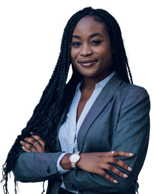 woman with long black hair wrapped in braids wearing a dark gray coat over a blue dress shirt with her arms crossed