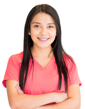young woman with long dark brown hair wearing small silver earrings and pink scrubs crossing her arms